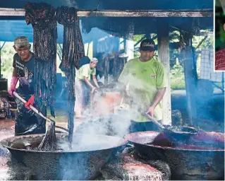  ??  ?? Art in the making:
Workers getting rid of excess wax and colouring at the Kamis Batik Kuala Terengganu factory, owned by Kamis (inset) in Kampung Banggol Durian in Serada, Kuala Terengganu. — Bernama