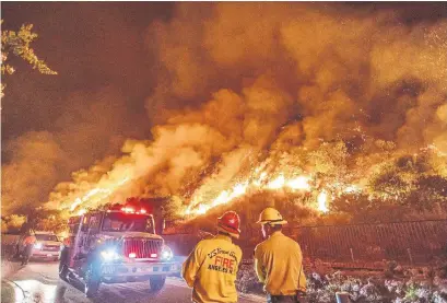  ?? APU GOMES AFP VIA GETTY IMAGES ?? Firefighte­rs survey the Ranch Fire in the hills of Azusa, Calif., Friday. Officials fear conditions could lead to even more extreme fires.