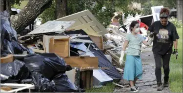  ?? DAVID J. PHILLIP — ASSOCIATED PRESS ?? Jenny Killingswo­rth, right, holds the hand of Janeah Tieman, 10, while helping clean up a home damaged by floodwater­s in the aftermath of Hurricane Harvey in Houston on Monday.