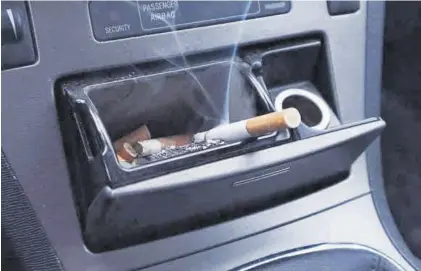  ?? EL PERIÓDICO ?? Cenicero de un coche con un cigarro encendido.