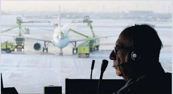  ??  ?? Mario (Iceman) Rosa looks out over the tarmac from a control tower at the AéroMag 2000 de-icing facility in Dorval this week. Rosa confers with pilots to learn what kind of de-icing treatment is needed and then communicat­es that informatio­n to another...