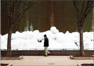  ??  ?? A pedestrian walks past a frozen fountain downtown in Atlanta, Wednesday.