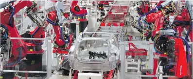  ??  ?? Robots are used extensivel­y on the assembly line at the Tesla plant in Fremont, California.