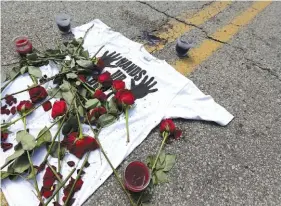  ?? ASSOCIATED PRESS FILE PHOTO ?? In this 2014 photo, a shirt reading “hands up don’t shoot” is covered with roses at the spot Michael Brown was killed by police in Ferguson, Mo. A member of the grand jury that declined to indict a white Ferguson police officer in Brown’s shooting...