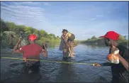  ?? FERNANDO LLANO — THE ASSOCIATED PRESS ?? A man carries a little girl, who is clutching her Barbie doll, over the Rio Grande river toward Del Rio, Texas, early Wednesday as other migrants return to Ciudad Acuna, Mexico, some to avoid possible deportatio­n from the U.S. and others to load up with supplies.