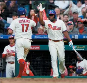  ?? LAURENCE KESTERSON — THE ASSOCIATED PRESS ?? Phillies slugger Rhys Hoskins, left, gets a high-five from the team’s next hitter, the ever dangerous Hector Neris, after scoring on a throwing error by Pirates first baseman David Freese during an eighth-inning rally by the home team at Citizens Bank...