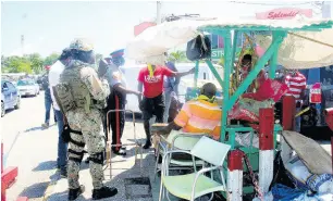  ?? PHOTO BY BRYAN MILLER ?? Members of the enforcemen­t team order a street vendor to relocate inside the Lucea Market or face sanctions yesterday as the Hanover Municipal Corporatio­n stepped up efforts to rid the streets of illegal vendors.