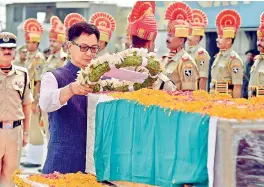  ?? — PTI ?? MoS for Home Kiren Rijiju lays a wreath on the coffin of BSF head constable Prem Sagar after it was brought at Palam Airport in New Delhi on Tuesday. When the body was taken to Lucknow, the jawan’s family members demanded that the coffin be opened....
