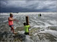  ?? DAN ANDERSON — THE ASSOCIATED PRESS ?? Lauren Dueitt, left, and John Payne, 6, right, play in the high tide waters caused by Tropical Storm Gordon on Tuesday in Dauphin Island, Ala.