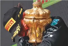  ?? AFP ?? ■ Lewis Hamilton with the trophy after winning the British Grand Prix at Silverston­e yesterday.