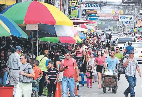  ?? FOTOS EFRAÍN V. MOLINA. ?? ECONOMÍA. La zona comercial de El Progreso luce abarrotada de compradore­s de la época.