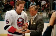  ?? AP FILE PHOTO BY RAY STUBBLEBIN­E ?? In this1988 photo NHL President John Ziegler presents an award to New York Islanders defenseman Denis Potvin prior to the Islanders’ game with the Washington Capitals at Nassau Coliseum in Uniondale, N.Y.