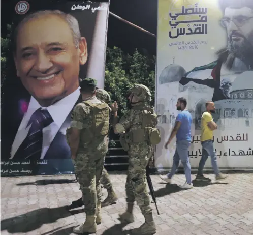  ??  ?? A poster of Hezbollah leader Hassan Nasrallah on a street corner in the village of Adaisseh near the Lebanese-Israeli border, above. A Lebanese army M60 tank during an official independen­ce day parade in the capital Beirut, left