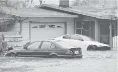  ??  ?? A partially submerged home and vehicles are seen during a winter storm in Petaluma, California. — Reuters photo