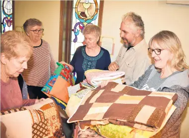  ?? MARY COMPTON/DAILY SOUTHTOWN ?? Trinity Lutheran Church members Donna Blatt, of Tinley Park, from left; Sally Przybyla, of Oak Forest; and Marilyn Pringle, of Tinley Park; present handmade quilts to Good Shepherd Church members Joel and Lori Powless, of Frankfort. The quilts are destined to go to people involved in disasters as well as domestic violence shelters.