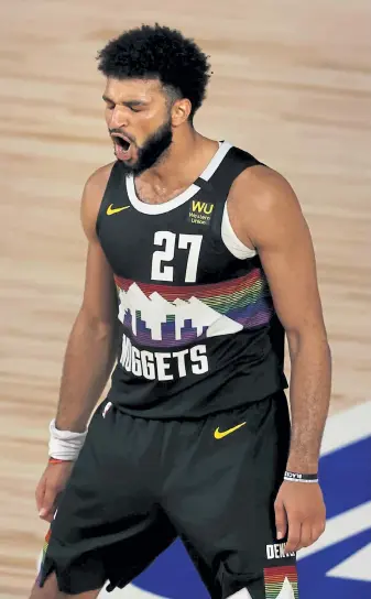  ?? Mike Erhmann, Getty Images ?? Denver guard Jamal Murray reacts after a sinking a shot during the second half of the Nuggets’ season-saving Game 5 win over Utah on Tuesday in Lake Buena Vista, Fla.