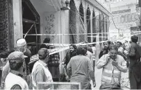  ?? Muhammad Sajjad / Associated Press ?? Rescue workers gather at a Shiite mosque in Peshawar, Pakistan, where at least 57 were killed by an explosion Friday.