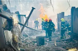  ?? UKRAINIAN EMERGENCY SERVICE ?? Ukrainian Emergency Service members scramble Friday to put out fires after missiles hit the city of Odesa. Several people died, and dozens were hurt.