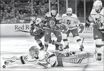  ?? Winslow Townson Associated Press ?? KINGS GOALTENDER Jonathan Quick dives to gather in a loose puck as the Bruins’ Danton Heinen (43) closes in during the second period of Saturday’s game. The Kings rallied late to tie Boston but lost in overtime.