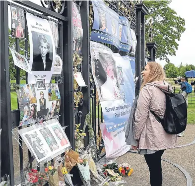  ?? Picture: Getty. ?? A woman admires the tributes to Princess Diana at the gates of Kensington Palace yesterday.