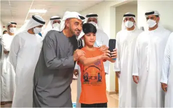 ?? WAM ?? Shaikh Mohammad takes a selfie with an Afghan boy at the Emirates Humanitari­an City, which is temporaril­y hosting families evacuated from Afghanista­n on their way to third countries. Below: Shaikh Mohammad interacts with Afghan families at the shelter.