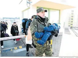  ?? DAREK DELMANOWIC­Z / EFE ?? Un militar traslada en brazos a un bebé en la frontera entre Ucrania y Polonia.