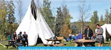  ??  ?? People stand in a Dene Nahjo camp, open to the public, at Somba K’e Park, near Frame lake and a playground for kids at the urban hide tanning camp.