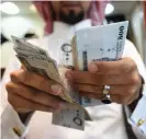  ?? ?? A man counts Saudi riyal banknotes at his jewellery shop in Riyadh. — afp file