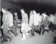  ?? ASSOCIATED PRESS ?? Elvis Presley (in checkered sport coat) and others inducted into the Army arrive at Fort Chaffee, Ark.