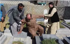  ??  ?? MUZAFFARAB­AD: Elderly Indian Kashmiri Muhammad Ashraf (center) is being helped by his son Muhammad Asghar (left) and a relative as he touches the grave of his mother at a graveyard on the outskirts of Muzaffarab­ad, the capital of Pakistani-administer­ed...