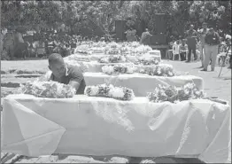  ?? ANDREW KASUKU/AP ?? Coffins for some of the ferry victims are lined up during a mass burial Sunday on Ukara Island, Tanzania. The ferry tipped over Thursday yards from the island’s dock.