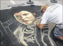  ?? KEVIN D. THOMPSON / THE PALM BEACH POST ?? David Lepore, a Wellington artist, uses chalk to paint Princess Leia from “Star Wars” at the 23rd annual Street Painting Festival in downtown Lake Worth.