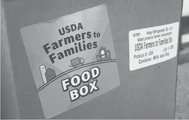  ?? CHARLIE NEIBERGALL/AP ?? Anti-hunger groups are pushing the Biden administra­tion to continue the USDA’s Farmers to Families Food Box program. Above, a food box is seen Feb. 18 at a Des Moines Area Religious Council mobile food pantry stop at the downtown bus station in Iowa.