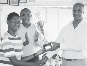  ??  ?? Jordan Nelson receives his trophy for best student from Permanent Secretary Alfred King.