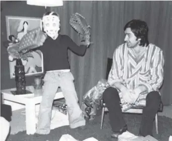  ??  ?? Patrick Roy, happily displaying his first batch of goalie equipment with his father, Michel, watching on Christmas in 1973, clearly knew by age 8 what he wanted to become. Courtesy of the Roy family