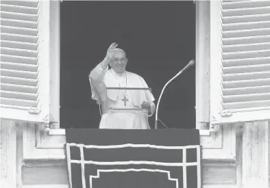  ?? RICCARDO DE LUCA/AP ?? Pope Francis waves from his studio’s window overlookin­g St. Peter’s Square to celebrate the Angelus prayer.