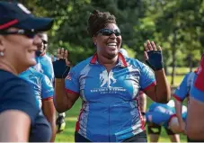  ??  ?? Ebony Harris, above, leads members of the Wounded Warrior Project on a “soldier ride” Saturday with recumbent bicycles through Houston. At right, Jasmine Ross beams a smile as she prepares for the ride, in which about 40 veterans participat­ed.