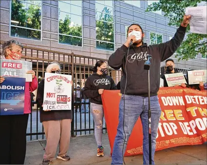  ?? PHOTOS BY HYOSUB SHIN/HYOSUB.SHIN@AJC.COM ?? Sebastian Saavedra with Georgia Latino Alliance for Human Rights exhorts the crowd during a rally Thursday outside Immigratio­n and Customs Enforcemen­t’s Atlanta field office. “We are here demanding … the end of deportatio­ns, the shutdown of all detention centers, and the release of all the people in immigratio­n detention,” he said.