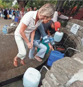  ??  ?? Residents of Cape Town, South Africa, collect drinking water from a mountain spring Friday in the midst of a severe water crisis.