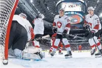  ?? MINAS PANAGIOTAK­IS THE CANADIAN PRESS ?? Swiss goalie Luca Hollenstei­n and teammates react after a Russian goal on the way to a 5-0 loss in the bronze medal game.