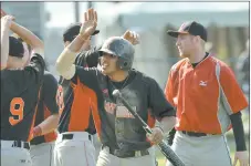  ?? PHOTO COURTESY OF SPORTSPIX ?? Rafael Garcia, center, is greeted after scoring the tie-breaking run in the 11th inning that helped No. 8 Mitchell College stun No. 1 Eastern Connecticu­t in the NCAA tournament Wednesday in Harwich, Mass.