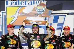  ?? (AP) ?? Martin Truex Jr., (center), poses with the winners trophy as he celebrates winning the NASCAR Cup series auto race in Richmond, Va., on Sept 11.