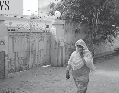  ?? B.K. BANGASH / THE ASSOCIATED PRESS ?? A Pakistani woman walks past the childhood home of London Bridge attack suspect Khuram Butt, in Jhelum, Pakistan, on Tuesday. Butt moved to Britain, working for Transport of London as a service clerk and Kentucky Fried Chicken and where he embraced...