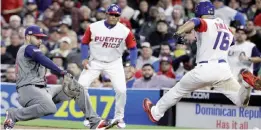  ??  ?? SAN DIEGO: US first baseman Eric Hosmer, left, misses the throw from third baseman Nolan Arenado as Puerto Rico’s Angel Pagan (16) arrives safely to first base during the sixth inning of a second-round World Baseball Classic baseball game Friday, in...