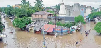  ?? — AFP ?? People wade through a flood street in Sangli, Maharashtr­a.