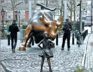  ?? BRENDAN MCDERMID / REUTERS ?? A cameraman films the Fearless Girl staring down the famous Charging Bull in New York’s financial district on Tuesday.