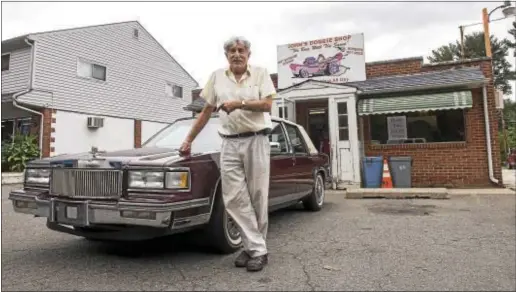  ?? RICK KAUFFMAN – DIGITAL FIRST MEDIA ?? Pete Eleutherio­u poses with his 1987 Cadillac DeVille outside his son’s business, John’s Doggie Shop, which began under Pete’s father 69 years earlier. They closed the door on the iconic eatery on the Conchester Highway for the last time Saturday.