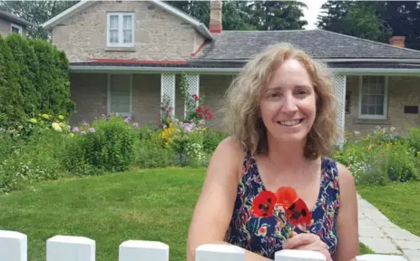  ?? SONIA DAY PHOTOS ?? Volunteer Val Harrison with some of the poppies that were planted in front of the Guelph birthplace of John McCrae, author of