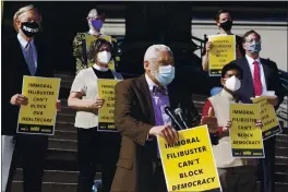  ?? SUSAN WALSH — AP PHOTO ?? Rev. Graylan Hagler, center, speaks outside the National City Christian Church in Washington. A coalition of interfaith leaders and activists met in Washington and online to demand an end to the filibuster, calling it an arcane and racist tactic that blocks the passing of moral policies.