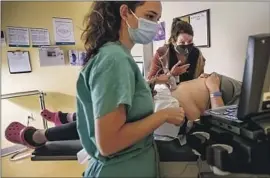  ?? ?? A PHYSICIAN and her resident perform an ultrasound at the clinic Thursday, a day before the Supreme Court majority struck down Roe vs. Wade.